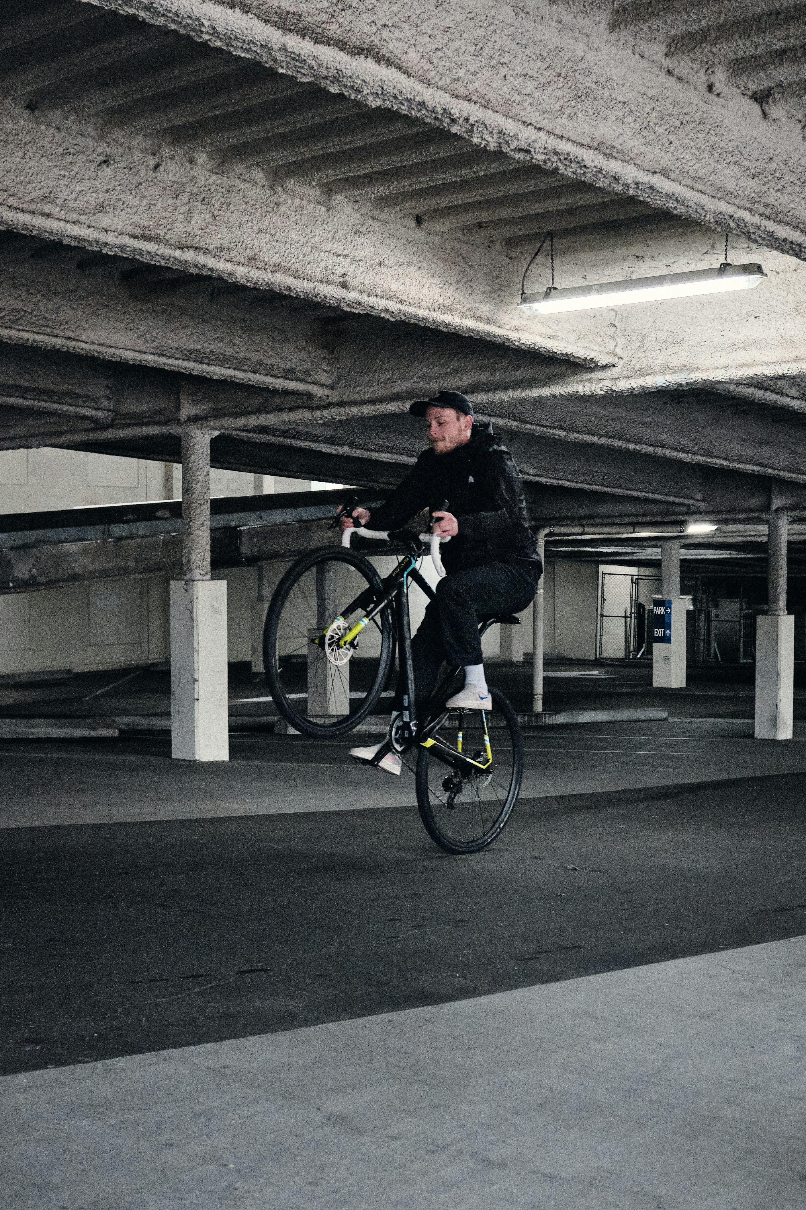 man in black jacket riding bicycle on gray concrete road during daytime